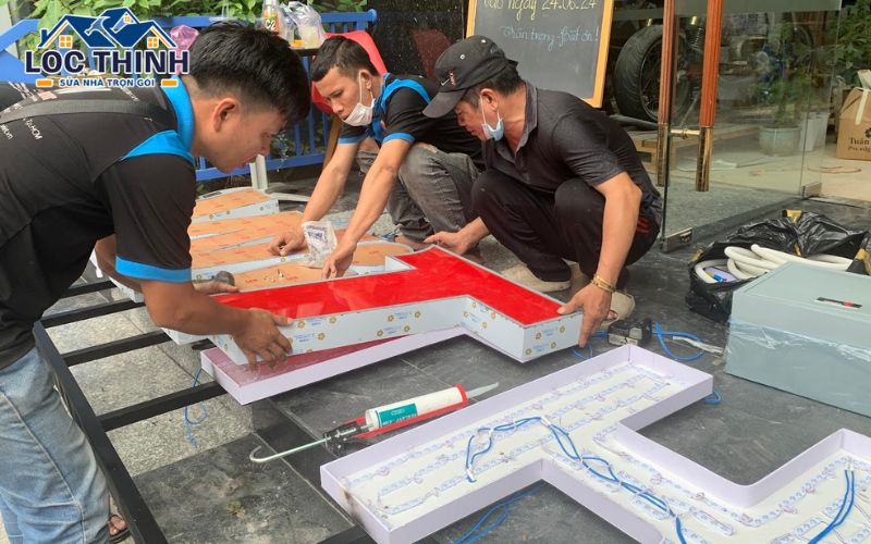 Đội thi công lắp chữ vào khung